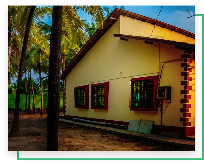 Side view of one of the cottages with coconut trees nearby